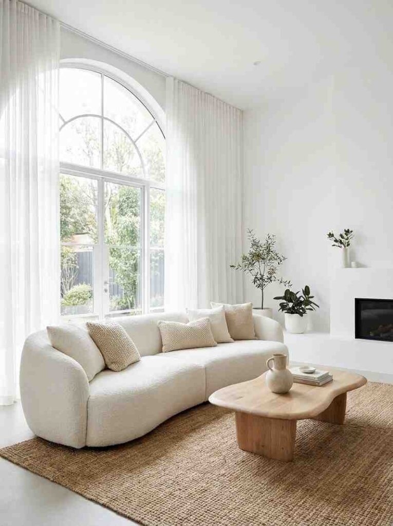 Spacious living room with a large curved white sofa as the centerpiece, 
