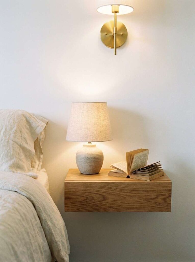 21 Small Bedroom Ideas 2026 Floating oak nightstand with brass sconce in a small bedroom